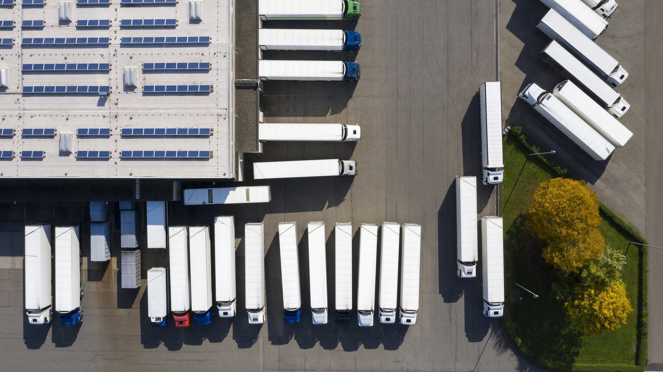 Aerial view of logistics distribution centre surrounded by multiple semi-trucks