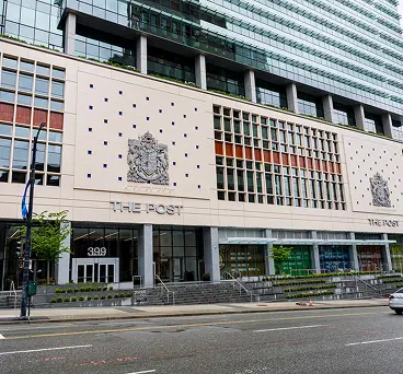 A modern commercial glass building integrated with a historic front facade.