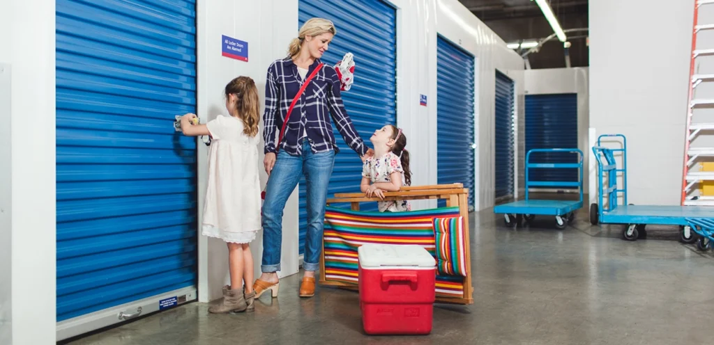 A mom and her daughters locking up a self storage unit.