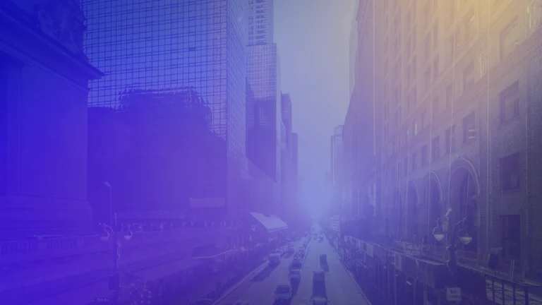 Urban street scene framed by tall office and historic-style buildings, viewed from above. Traffic moves along the road below, while a blue and purple gradient overlay with soft light flares creates a modern, abstract appearance. The cityscape fades into a bright, hazy focal point in the distance.