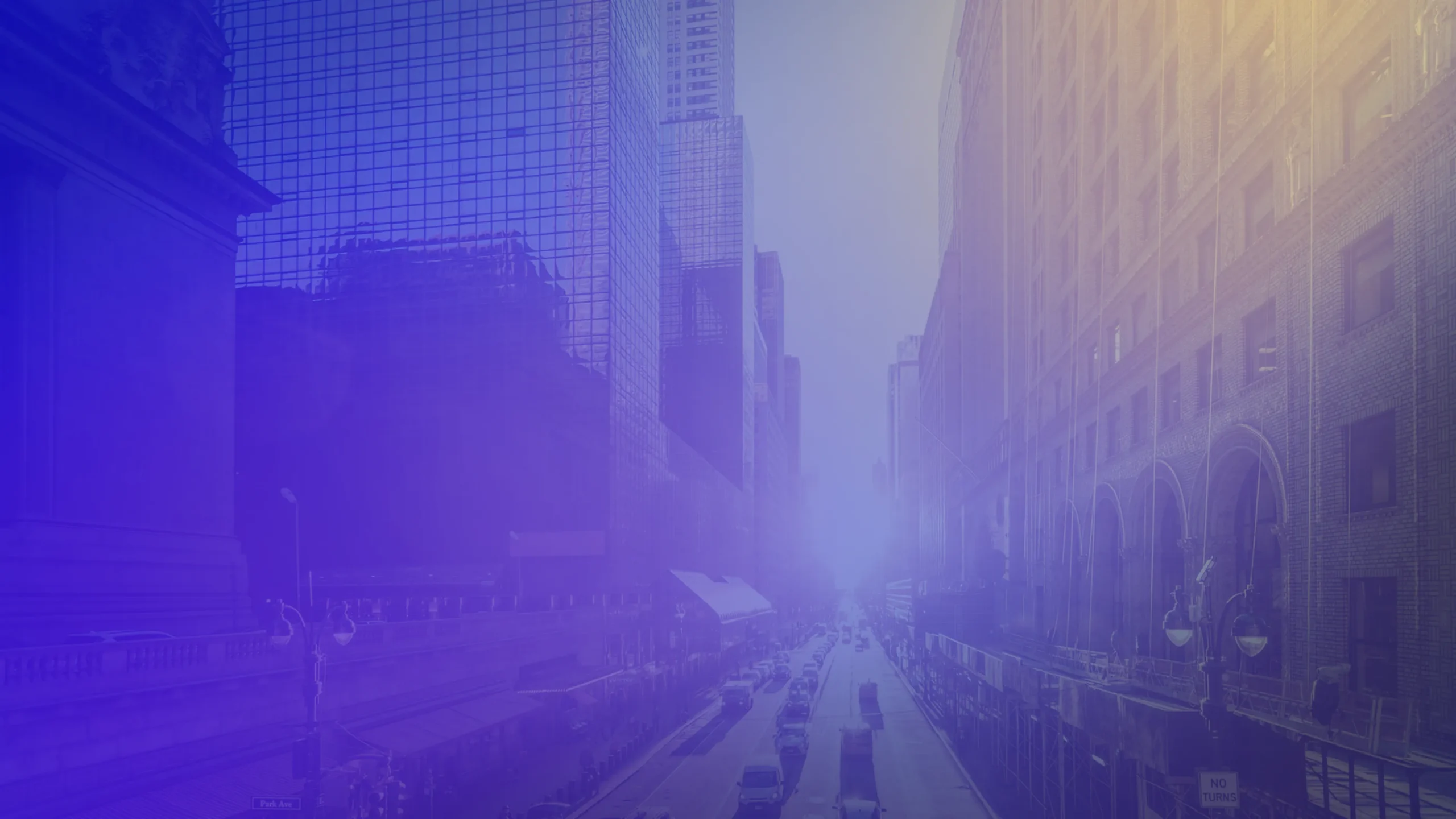 Urban street scene framed by tall office and historic-style buildings, viewed from above. Traffic moves along the road below, while a blue and purple gradient overlay with soft light flares creates a modern, abstract appearance. The cityscape fades into a bright, hazy focal point in the distance.