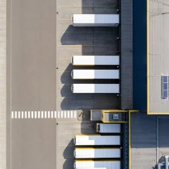 An aerial view of parked trucks and a building with solar panels.